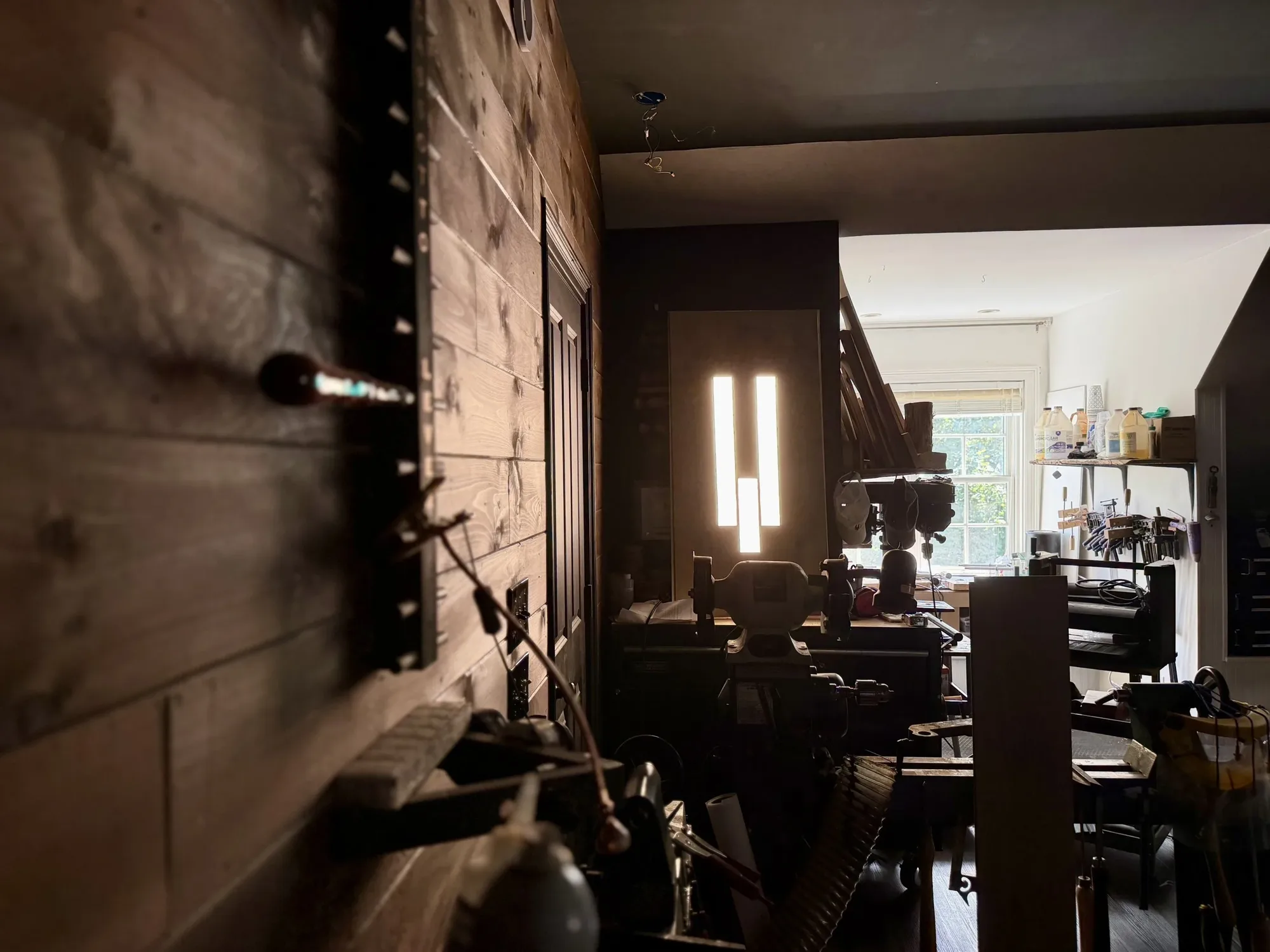 Randy's workshop: a wall of tools, a bench grinder and clamps racked by the window